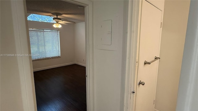 hallway featuring a textured ceiling, dark hardwood / wood-style flooring, and electric panel