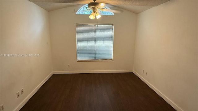 empty room with a textured ceiling, dark wood-type flooring, lofted ceiling, and ceiling fan