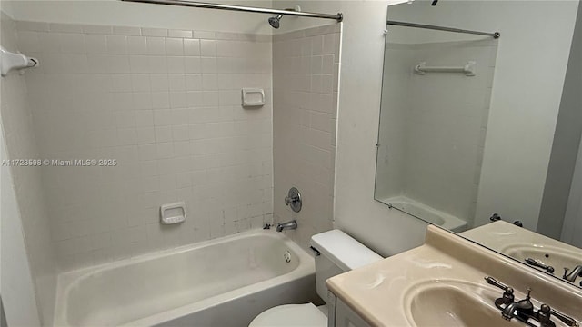 full bathroom with toilet, tiled shower / bath, and vanity