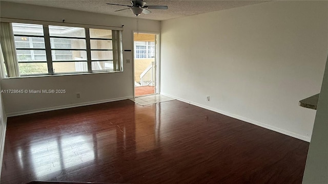 spare room featuring a textured ceiling, ceiling fan, and dark hardwood / wood-style flooring