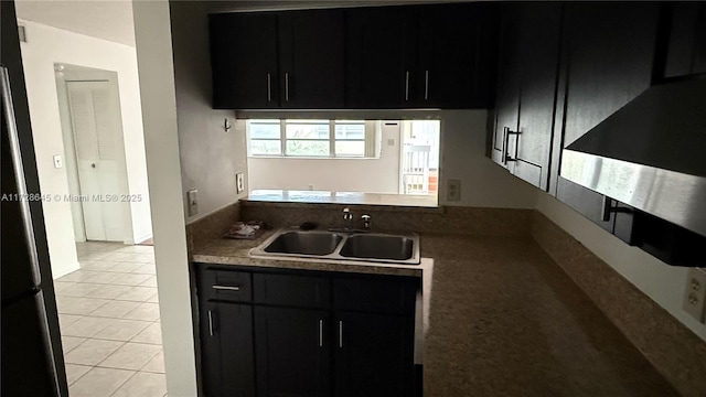 kitchen with sink, light tile patterned floors, and stainless steel refrigerator