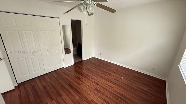 unfurnished bedroom featuring ceiling fan, a closet, dark hardwood / wood-style floors, and a textured ceiling