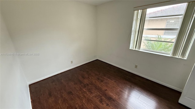 unfurnished room featuring a wealth of natural light and dark hardwood / wood-style floors