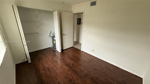 unfurnished bedroom featuring dark wood-type flooring and a closet