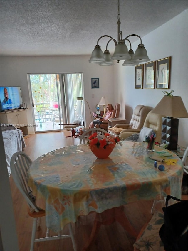 dining area featuring an inviting chandelier and a textured ceiling