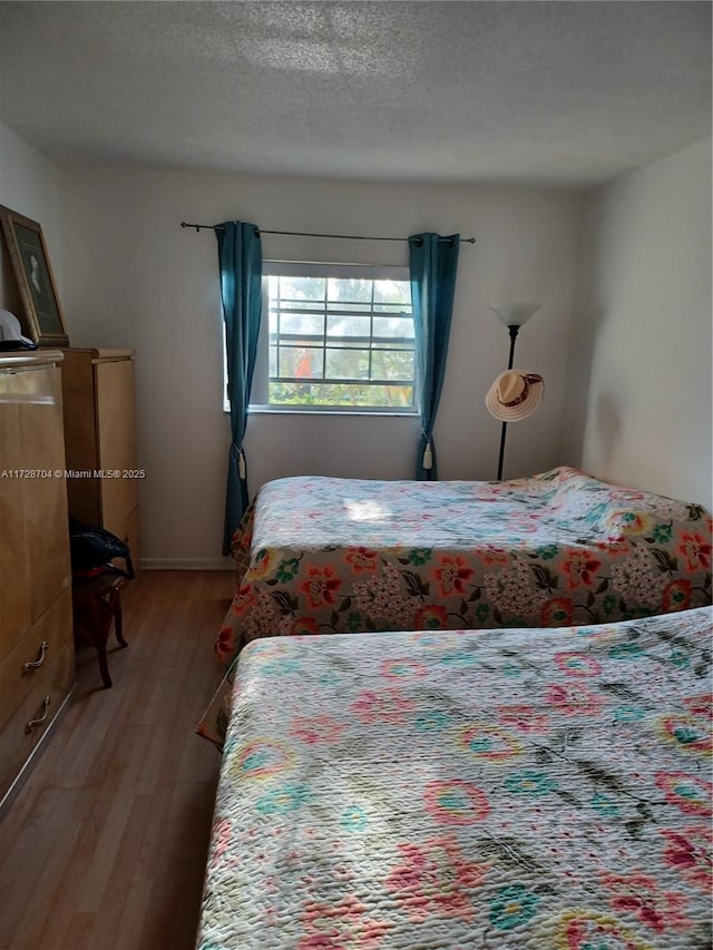 bedroom featuring a textured ceiling and wood-type flooring