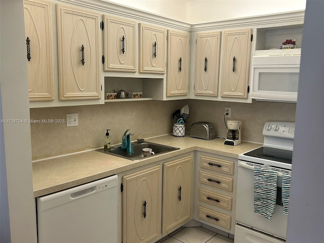 kitchen with white appliances, light brown cabinetry, and sink