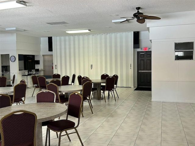 tiled dining room with a textured ceiling and ceiling fan