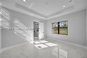 unfurnished bedroom with a raised ceiling