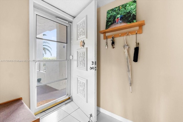 doorway to outside with light tile patterned floors and a textured ceiling