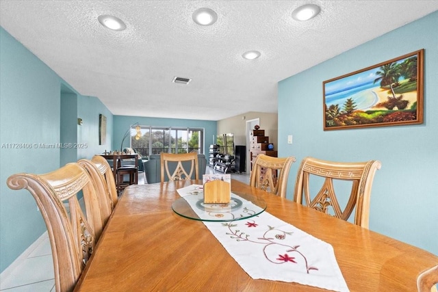 dining space featuring a textured ceiling and hardwood / wood-style floors