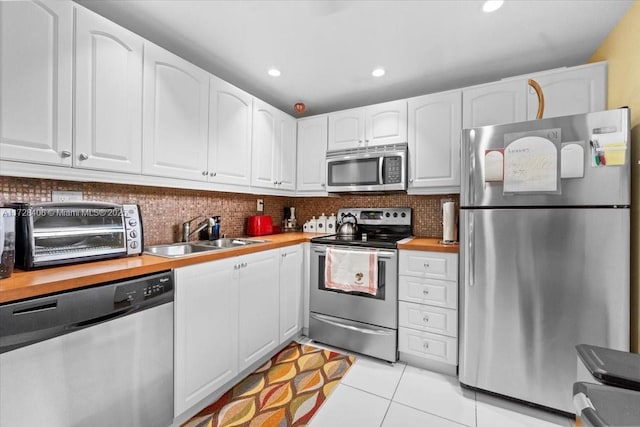 kitchen with backsplash, sink, stainless steel appliances, and white cabinetry