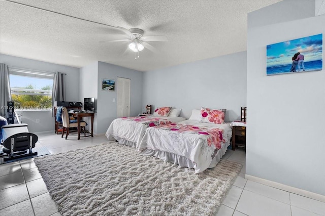 bedroom featuring ceiling fan, a textured ceiling, a closet, and light tile patterned flooring