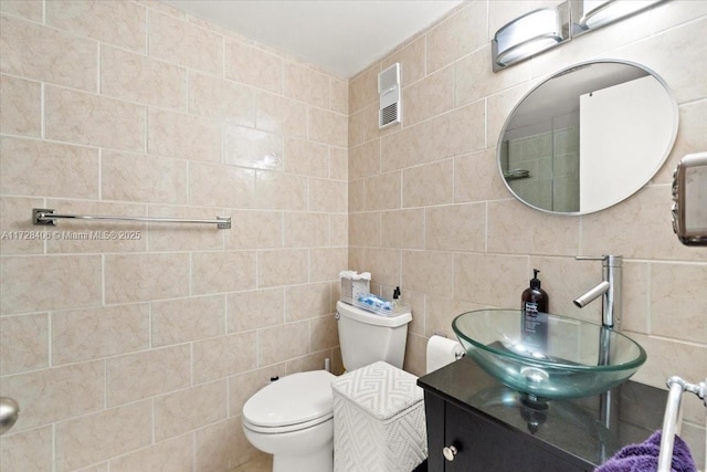 bathroom featuring toilet, tile walls, and vanity