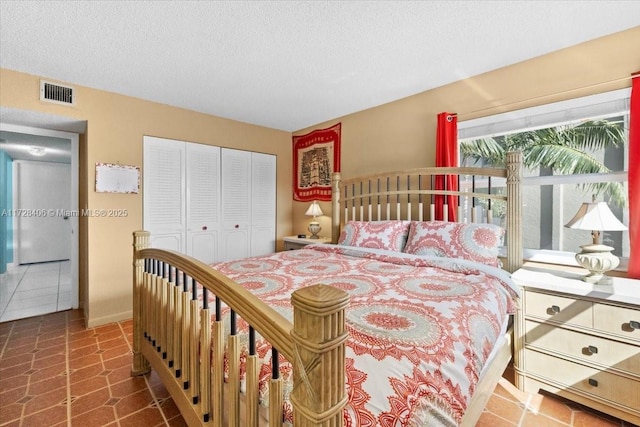 bedroom featuring a textured ceiling, a closet, and tile patterned flooring