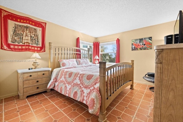 tiled bedroom featuring a textured ceiling