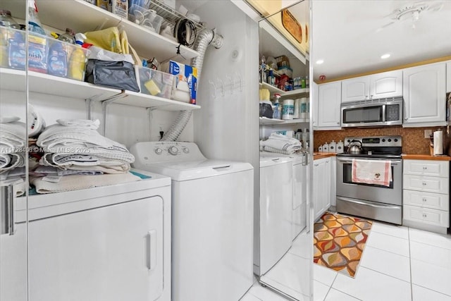 washroom with light tile patterned floors and washing machine and clothes dryer