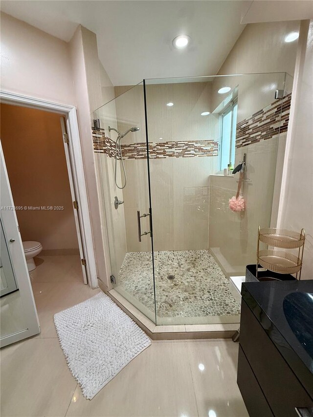 bathroom with vanity, tile patterned flooring, a shower with door, and toilet