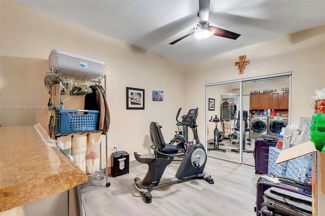 workout room featuring washer and dryer, ceiling fan, and light hardwood / wood-style flooring