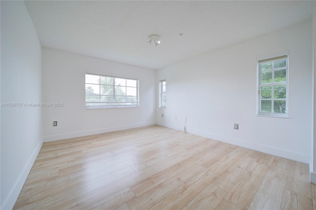 unfurnished room featuring a textured ceiling and light hardwood / wood-style floors