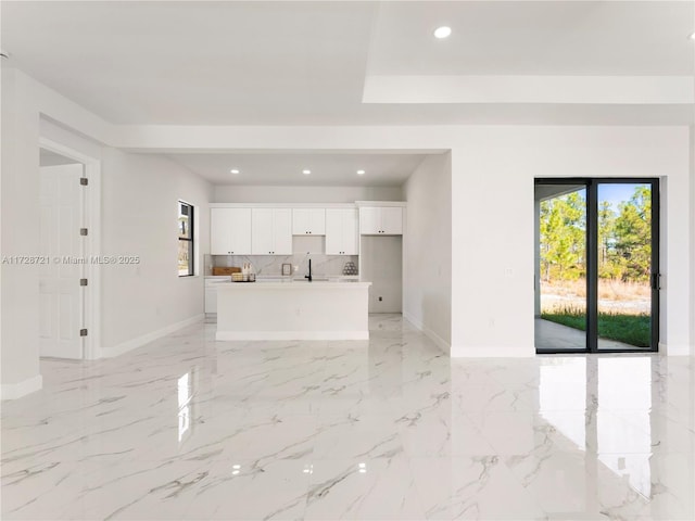 unfurnished living room with sink and a wealth of natural light