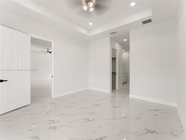 spare room featuring ceiling fan and a tray ceiling