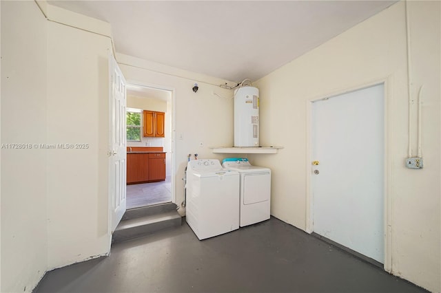 clothes washing area with washer and dryer and water heater