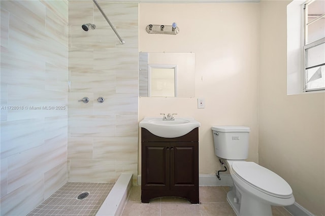 bathroom with vanity, a tile shower, tile patterned floors, and toilet