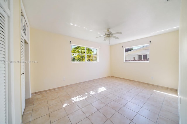 unfurnished bedroom with light tile patterned flooring, ceiling fan, a closet, and multiple windows