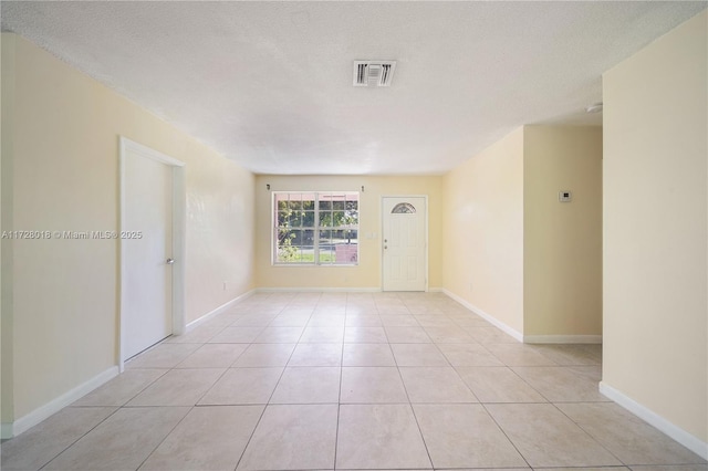 unfurnished room featuring light tile patterned floors and a textured ceiling