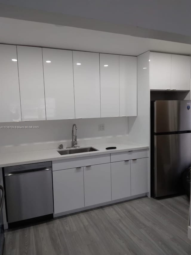 kitchen featuring appliances with stainless steel finishes, sink, and white cabinetry