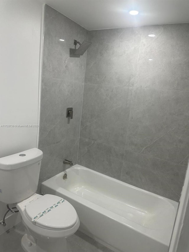 bathroom featuring toilet and tiled shower / bath combo