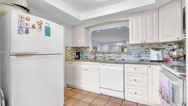 kitchen featuring tasteful backsplash, sink, white appliances, and white cabinetry