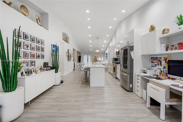 kitchen with a breakfast bar, a center island, pendant lighting, stainless steel appliances, and white cabinets