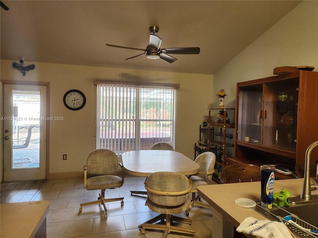 dining space featuring ceiling fan, vaulted ceiling, and sink