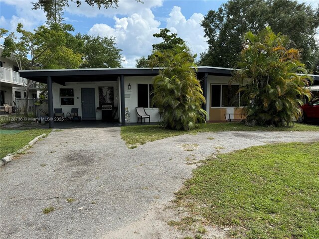 view of front of property with a front yard and a carport