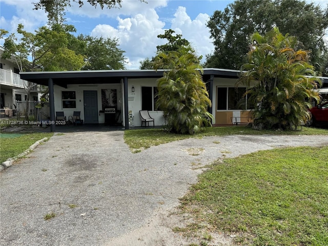 view of front of property featuring a front yard and a carport