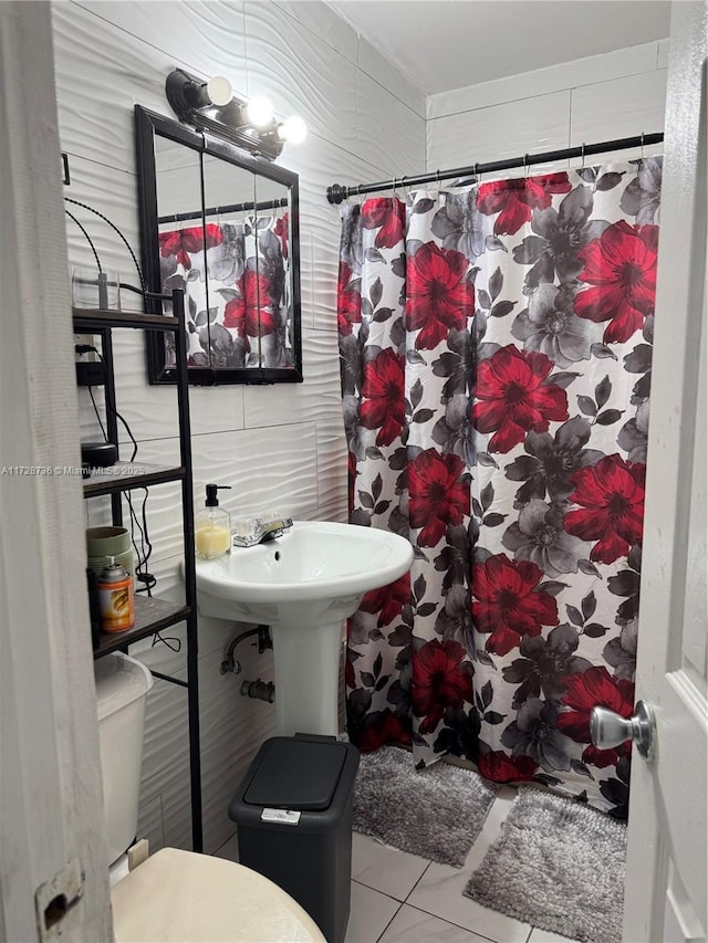 bathroom featuring curtained shower, tile patterned floors, and toilet