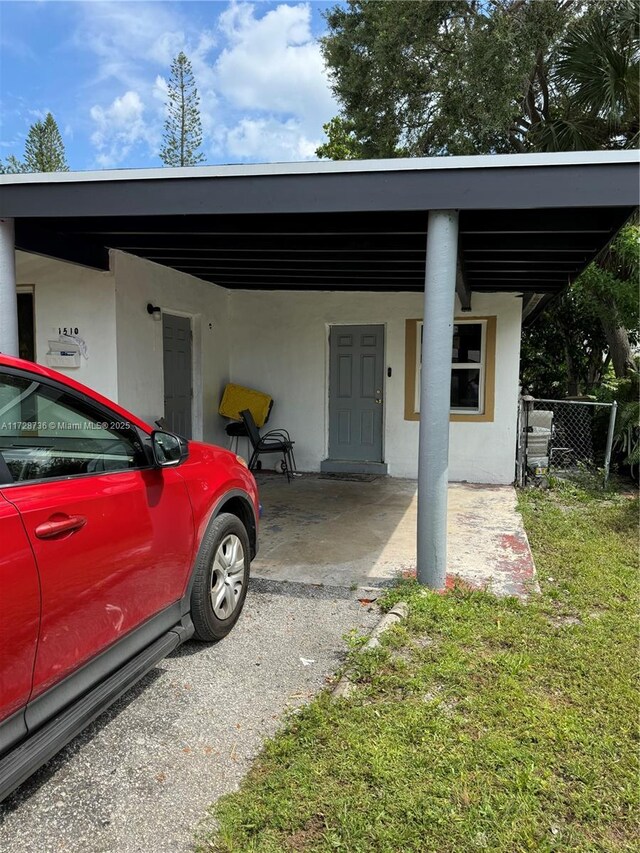 view of parking with a carport and a lawn