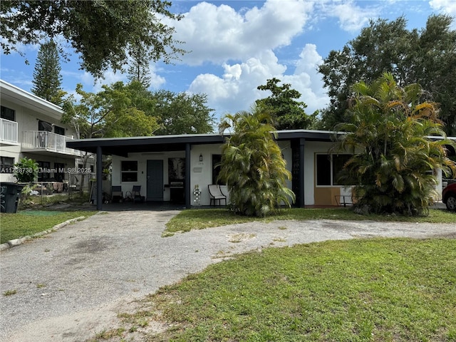 view of front of property with a carport and a front yard