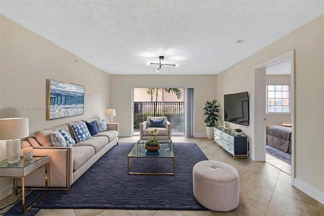 2009 SE 10th Ave Unit 302, Fort Lauderdale, FL 33316 - living area featuring healthy amount of natural light, tile patterned flooring, baseboards, and a textured ceiling