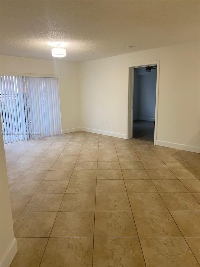 spare room with light tile patterned floors and a textured ceiling