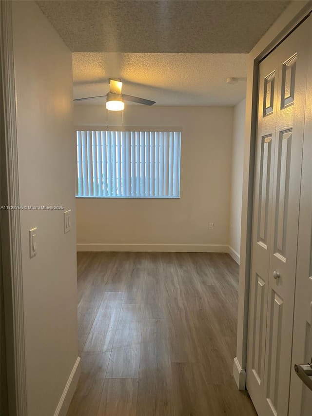 unfurnished room featuring ceiling fan, a textured ceiling, and hardwood / wood-style floors