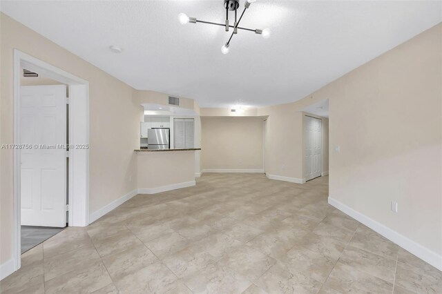 2009 SE 10th Ave Unit 302, Fort Lauderdale, FL 33316 - unfurnished living room with a chandelier and baseboards