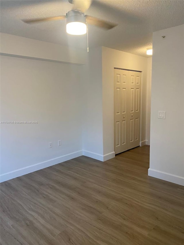 spare room featuring ceiling fan, a textured ceiling, and dark hardwood / wood-style flooring