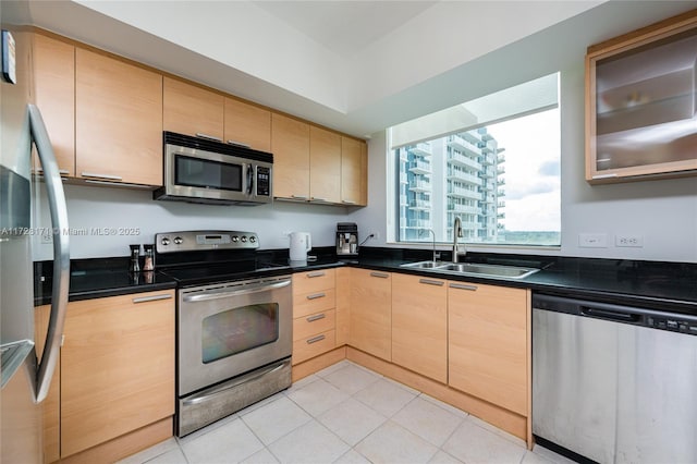 kitchen with appliances with stainless steel finishes, sink, and light brown cabinets