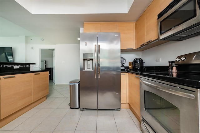 kitchen with light tile patterned flooring, appliances with stainless steel finishes, and light brown cabinets