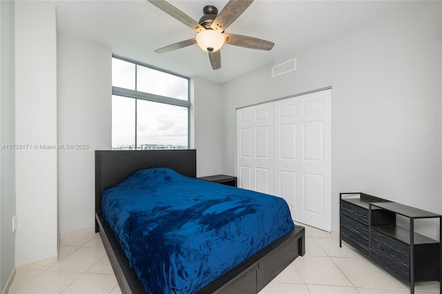 bedroom featuring ceiling fan, light tile patterned floors, and a closet