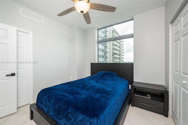 bedroom with ceiling fan and light tile patterned flooring