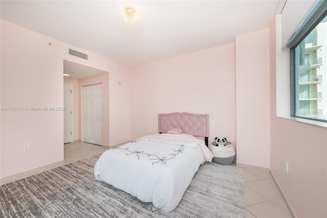 tiled bedroom with a closet